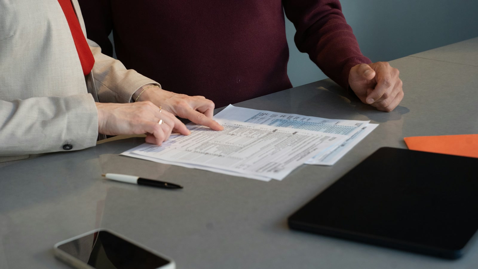Two people reviewing an employment contract at a desk