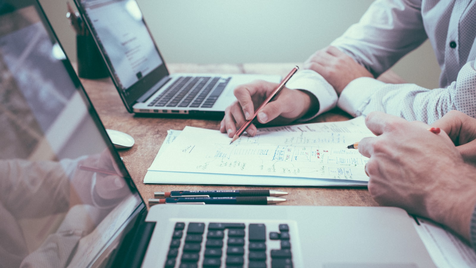 HR consultant in Adelaide reviewing plans and documents with a client at a desk